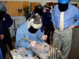 photo of student welding with secretary kuperus at NBC